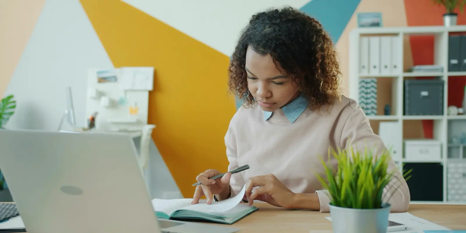 Young woman taking notes at her laptop