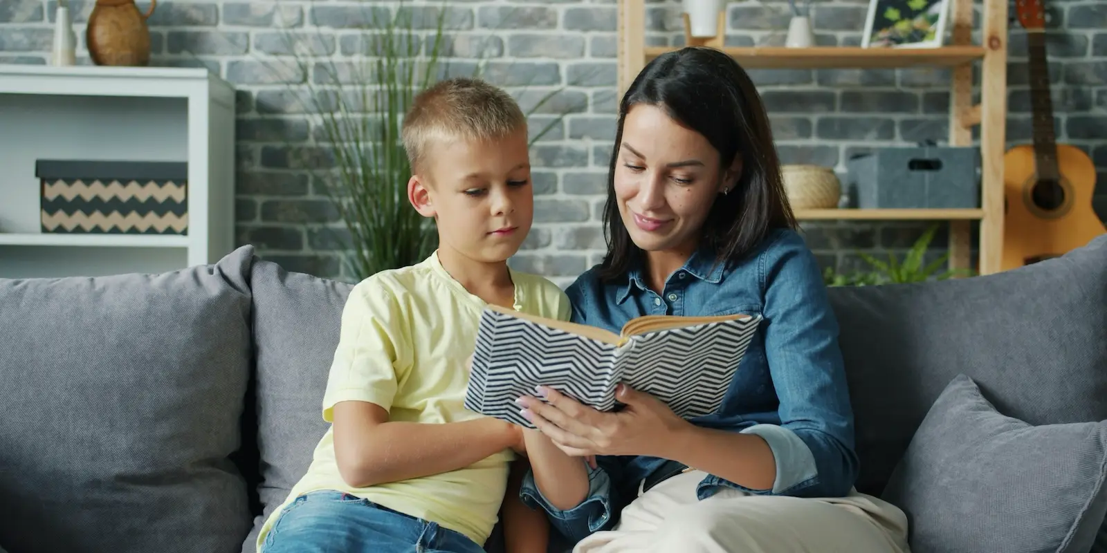 Young boy and woman reading together